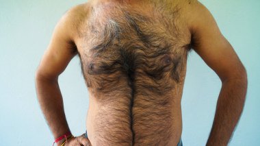 Kıllı göğsünü kameranın önünde gösteren bir adam. Gömleksiz erkek koltuk altı ve vücut kılları. Orta yaşlı portresi