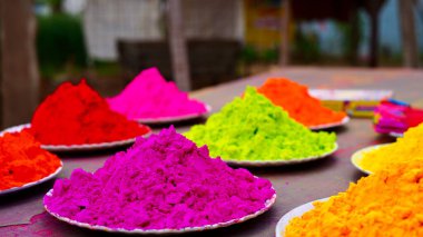 Hint Holi Festivali 'nin kapalı çekimleri masanın üzerinde beyaz tabaklarla izole edildi. Hindistan 'da Gulal ile renkli Holi kutlamaları. Boya konseptiyle dekorasyon. Dhulandi. Üst görünüm