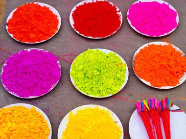 Hint Holi Festivali 'nin kapalı çekimleri masanın üzerinde beyaz tabaklarla izole edildi. Hindistan 'da Gulal ile renkli Holi kutlamaları. Boya konseptiyle dekorasyon. Dhulandi. Üst görünüm