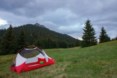 Yağmursuz bir şekilde, çimde dağ kolunun üzerinde, iç çadır bedenini aç. Arka planda Velky Rozsutec. Mala Fatra Dağları, Slovakya.