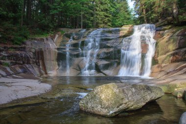 Mumlava şelalesi, ön plandaki granit taşın içinde. Dağ Nehri Mumlava, Krkonose Ulusal Parkı, Çek Cumhuriyeti, yaz öğleden sonra.