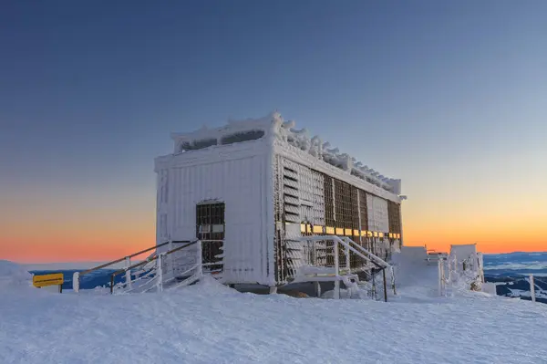 Wooden building of new post office with souvenirs and postcards in snezka, mountain on the border between Czech Republic and Poland, winter, sunrise time.