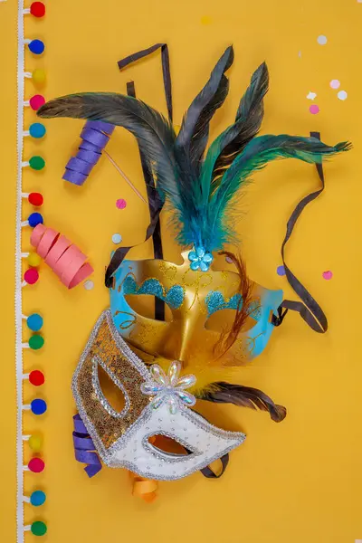 Dwie Maski Karnawałowe Razem Zdobione Piórami Konfetti Kolorowe Serpentyny Pionowym — Zdjęcie stockowe