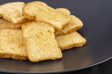 Siyah tabakta tereyağlı, çıtır çıtır ekmek.