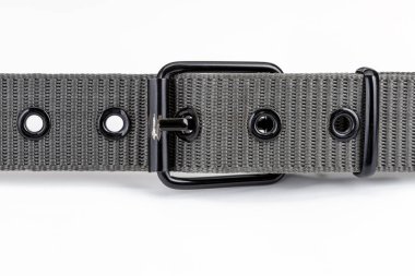 Metal tokalı gri naylon kemer, deseni ve tasarımı sergileniyor. Kemer birden fazla göz ve sağlam, şık görünümlü, gündelik veya resmi kıyafetler için ideal.