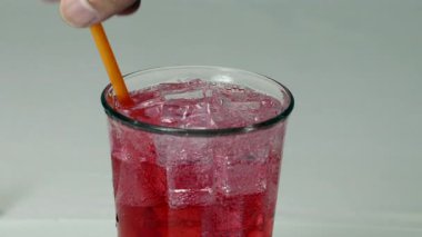 Red Soda 'nın tazelenmesi Buz Küpleri ile Bardağa Doldurulması ve Canlı Renk ve Köpüklerle İçmeye Davet Edilmesi, İçeceklerin Tazelenmesi İçin Turuncu Saman Kullanımı