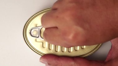 Altın kapaklı, beyaz arka planlı ve açılması zor bir et konservesi açmanın en iyi görüntüsü..