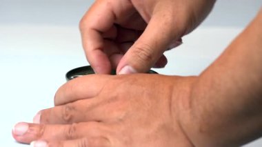 Ton balığı konservesini tuzlu suda, elleri beyaz arka planda açmak zor.