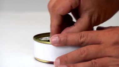 Altın kapaklı, beyaz arka planlı ve açılması zor bir et konservesi açmak..