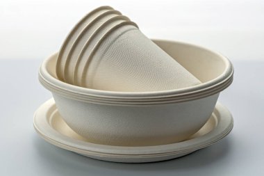 Çevreye duyarlı yemek için sürdürülebilir sofra takımı seçenekleri sunan, tarafsız arka planda yığınla çevre dostu tek kullanımlık kağıt kaseler ve tabaklar