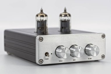 Antika bir tüp ses yükseltici ön görünüm gümüş metal çanta iki vakum tüpü üç kontrol düğmesi treble bas ses düğmesi güç anahtarı için beyaz arka planda izole edilmiş