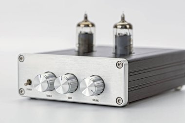 Vakum tüplü gümüş ses yükselticisi ön panel üç kontrol düğmesi beyaz arka planda izole edilmiş modern tasarım yüksek sadakat retro tarzı temiz ve zarif