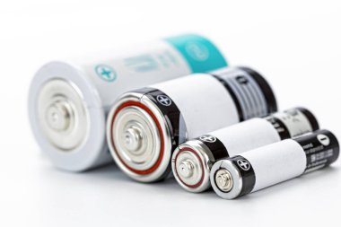 Çeşitli boyutlarda batarya silindirik batarya alkali şarj edilebilir enerji deposu metalik beyaz arka plan teknolojisi kavramını kapat