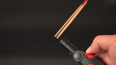 Çakmak çakmaklı tütsü çubuğu. Çakmağı yakın tutarak tütsü yakıyor. Duman yükseliyor, ruhsal ayin yapıyor.