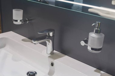 Beyaz modern dikdörtgen seramik lavabo, krom musluk, şeker kutusu ve diş fırçası tutacağı. İç mekan