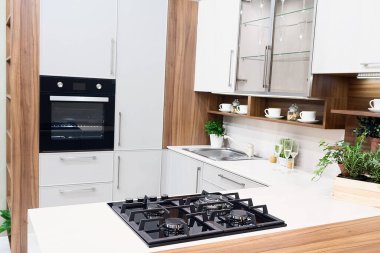 Beyaz dolapları ve adası olan bir ev mutfağı. İç mekan