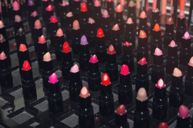 Bir kozmetik mağazasında düzgünce sergilenen canlı ruj dizisi. Güzellik endüstrisi