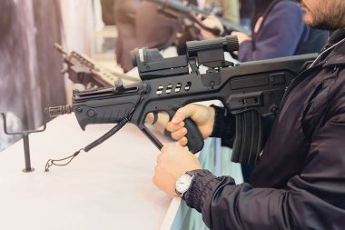 Alıcı bir silah dükkanından otomatik bir tüfek seçer. Nefsi müdafaa