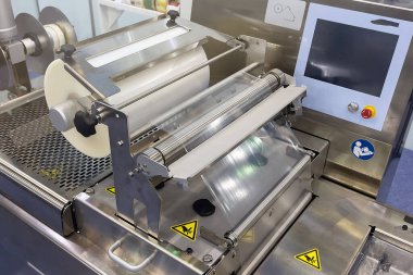 Gıda ürün fabrikasındaki otomatik paketleme makinesinin plastik ambalaj filmi. Sanayi