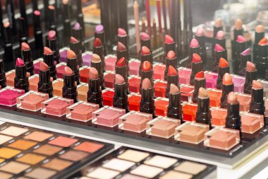 Bir kozmetik mağazasının vitrininde farklı ruj renkleri ve göz gölgeleri