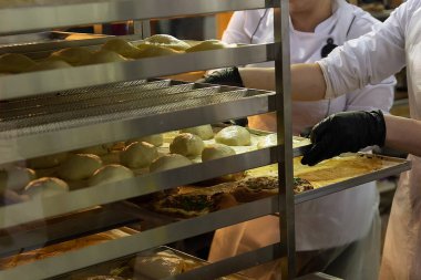 Fırında zanaatkâr işçiler, lezzetli ekmek ve hamur işleri yapıyorlar. Gıda endüstrisi