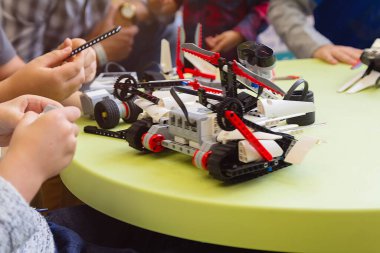 Çocuklar robotik dersinde model montajı üzerinde çalışıyorlar. Eğitim