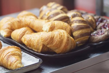 Pastanenin tezgahında taze kruvasan ve ekmek pastası sergileniyor. Yiyecek.