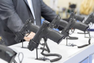 Silah deposunun camında satıcı ve tabancalar var. Satılık.