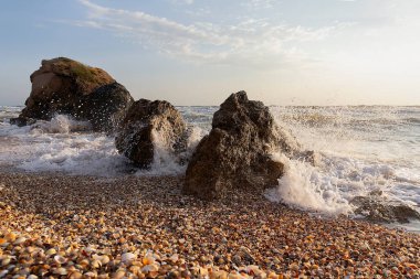 Dalgalar deniz kıyısında taşlarla çarpışıyor. Kırım