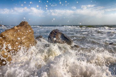 Dalgalar kayalar arasında sahilde yanılmak. Doğa