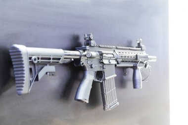 Silah deposunun penceresinde el bombası atan otomatik bir tüfek var.