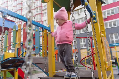 Evin yakınındaki oyun parkında sevimli bir bebek oynuyor. İnsanlar