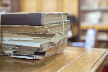 Masanın üzerinde bir sürü eski kitap var.