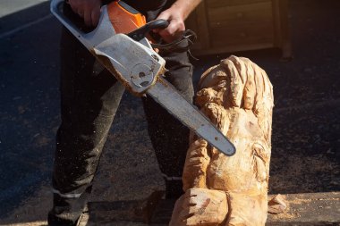 Tahta oyma yapmak için elektrikli testere kullanan bir adam. Yetenek ve hobi