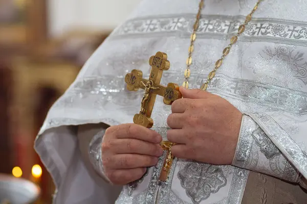 Kilisede elinde altın haçla bir Ortodoks rahibi. Ortodoks geleneği ve inancı. Dua için ekipman. Tanrıya dua et.