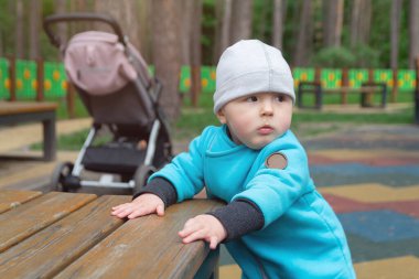 Çocuk serin havada parktaki oyun alanında oynar. İnsanlar