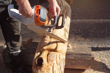 Tahta oyma yapmak için elektrikli testere kullanan bir adam. Yetenek ve hobi