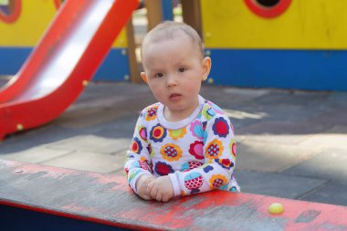 Bebek güneşli bir günde parkta oyun parkında oynar. İnsanlar