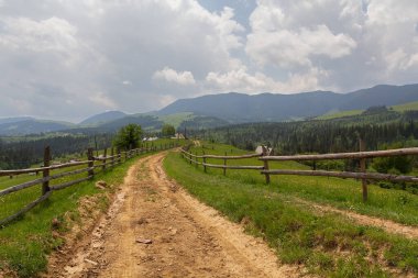 Dağlardaki kırsal yol ve çitler. Karpatlar