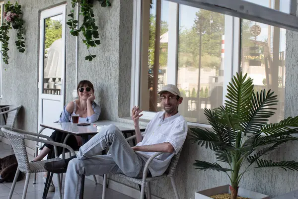 Gençler bir sokak kafesinde masada oturuyorlar.