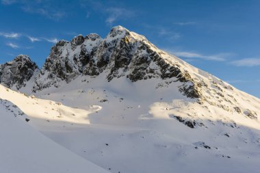 Zirve (Kozi Vrch, Kozi Wierch) Polonya Tatra Dağları 'nda kışın batan güneşin ışınlarıyla aydınlanır..