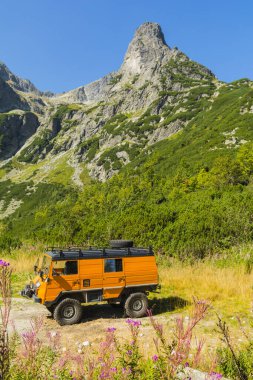 Tatranske Matliare, Slovakya - 05 Eylül 2024: Tatra Dağları 'ndaki Chata pri Zelenom plese dağ sığınağının ekipmanlarının bir parçası olan turuncu bir Steyr-Puch Pinzgauer 710 kamyonu.