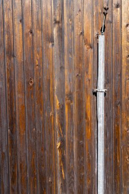 Binanın ön cephesindeki kahverengi tahtalara bir paratoner parçası monte edilmiş..