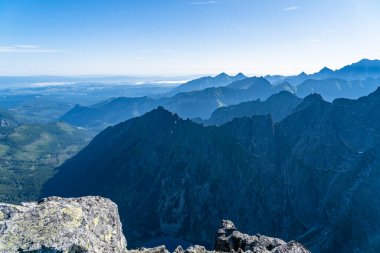 Dağ sırtları arasında sabah sisleri. Zirveden görüntü.