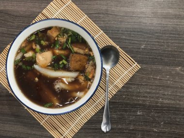 Çin usulü şehriye çorbası ya da pirinç ununu bambu hasırının üzerine koyulmuş koyu kahverengi bir fincana yapıştır.