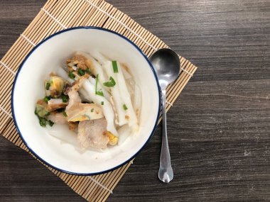 Çin usulü şehriye çorbası beyaz bir fincanda, bambu zemininde, koyu kahverengi bir masada