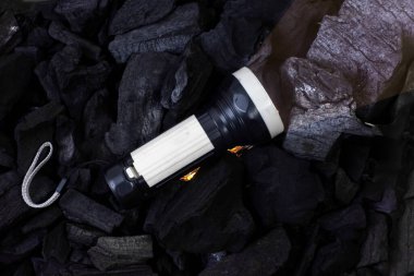 Karanlık bölgeyi aydınlatmak için bir el feneri. Arkası siyah pil.