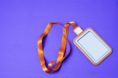 Boş turuncu çalışan kartı, mor arkaplana yerleştirilmiş kayışla mesajlar ya da fikirler eklenirken net görünsün.