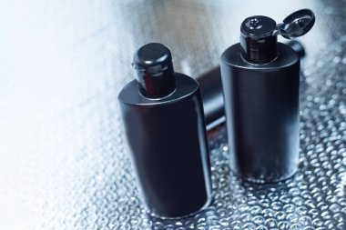 Yansıtıcı ve bulanık arka planda siyah plastik maket şişe