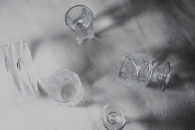 Küçük şarap kadehleri. Kalıpların çoğu beyaz, gri arka planda, hafif bir parıltıyla serili..